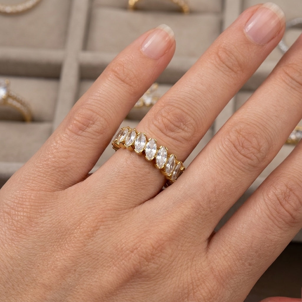 Gold ring with diamonds on a hand, with a jewelry box in the background