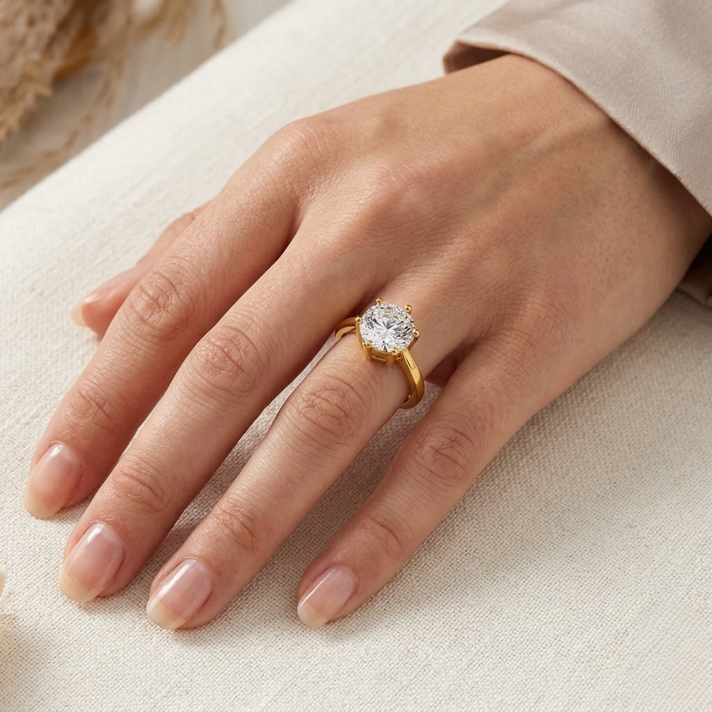 Gold ring with a diamond on a hand against a neutral background