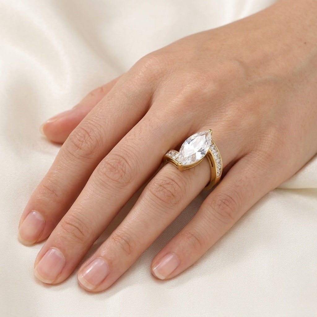 Gold ring with a large diamond on a hand against a white background