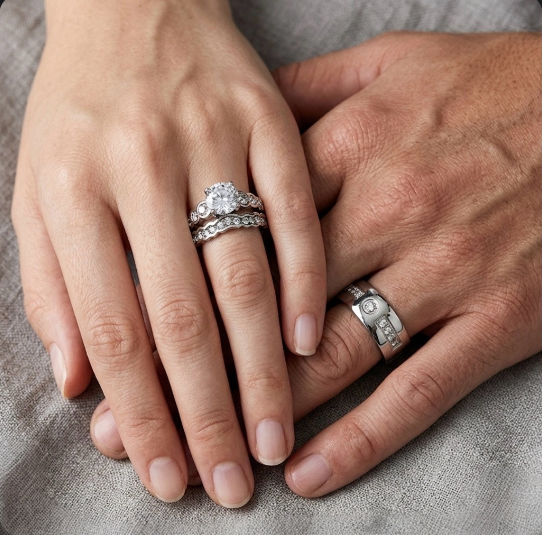Close-up of two hands with diamond rings on a neutral background